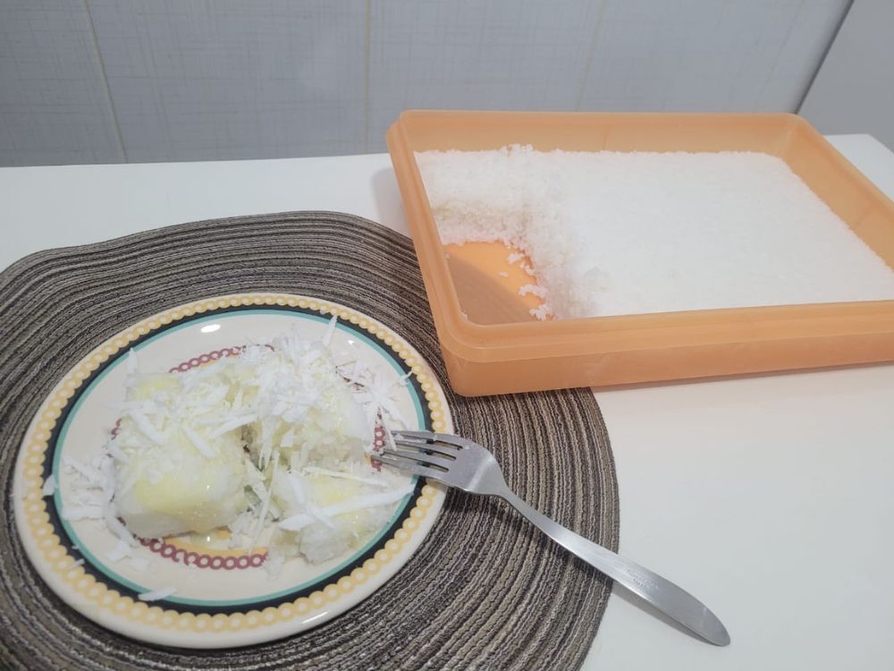 Bolo de tapioca (ou cuscuz de tapioca) servido com leite condensado e coco ralado.